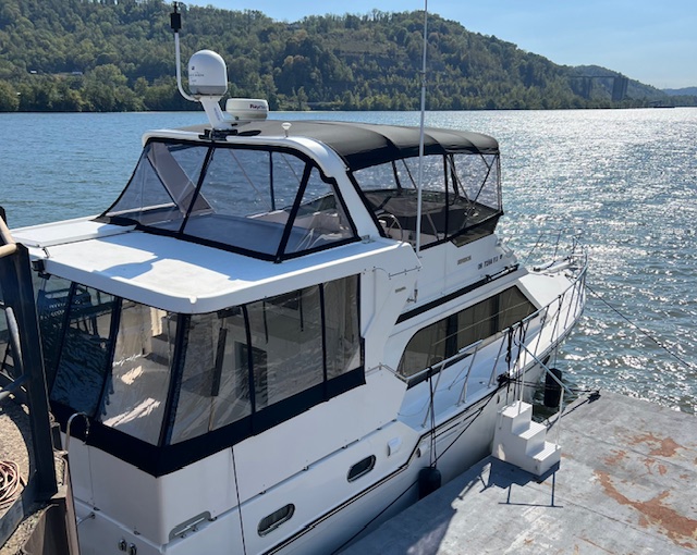 Houseboat with a black custom marine enclosure and clear screens by Erbco